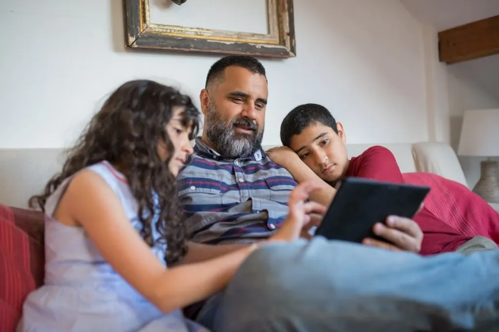 Image of family group browsing photos on a tablet.